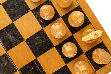 Old wooden chess pieces on a chessboard, macro, top view.