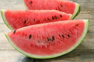 Slices of tasty ripe watermelon on wooden table, closeup