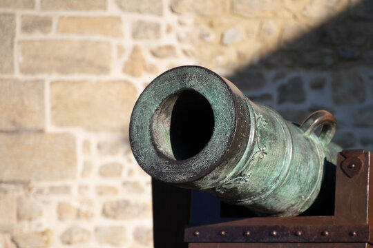 Cannon muzzle pointing. Antique bronze and wood cannon