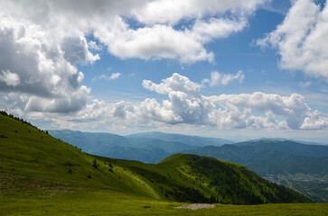 Fototapeta na wymiar Summer landscape with green mountain slopes covered clouds shadows in Ukrainian Carpathians. Travel and adventure concept