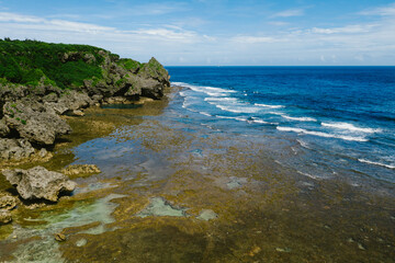 Fototapeta na wymiar Tide pools, waves and blue ocean cliffs on coastline of island