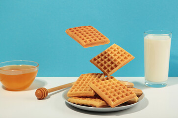 Belgian waffles flying in air on background.