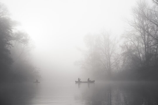 Two boats on the river on a thick foggy morning