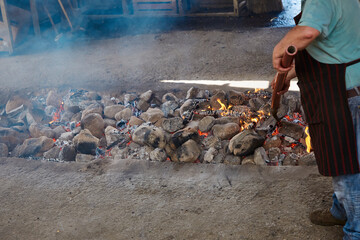 Stones heating in a well to cook curanto. Shovel, fire, smoke and rocks. Typical food of the...