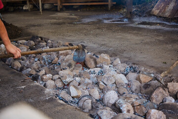 Stones heating in a well to cook curanto. Shovel, fire, smoke and rocks. Typical food of the Argentine Patagonia.