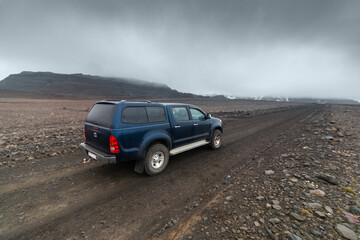 Obraz na płótnie Canvas Blue SUV car driving in highlands Iceland view over the car hood
