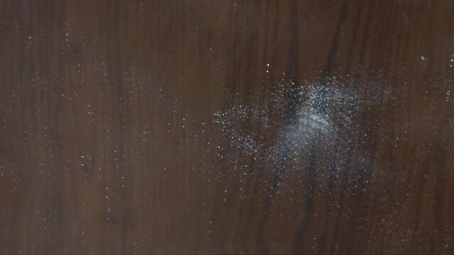 A hammer hitting and breaking a mirror into lots fragments with wooden background