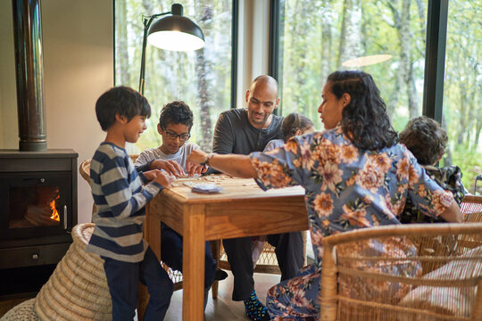 Family playing scrabble at dining table