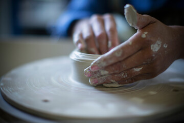 Close up hands of woman using pottery wheel