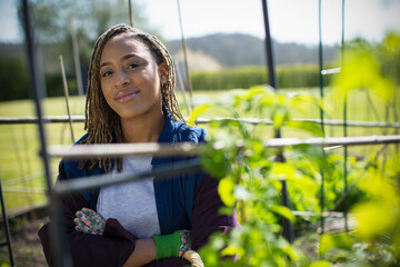 Portrait confident young woman in sunny garden