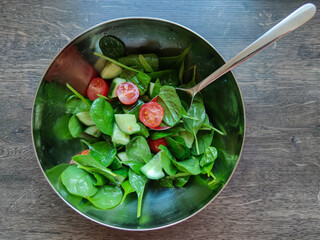 Top view of green healthy salad with other colorful vegetables such as cherry tomato and cucumber