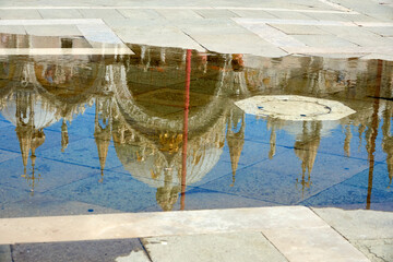 Basilica in San Marco square in Venice, reflected on a puddle after the end of the high tide, or aqua alta