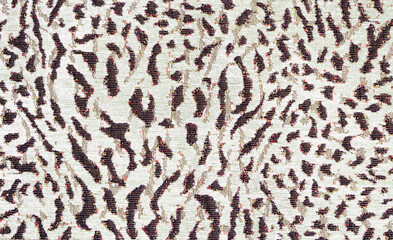 Leopard print on thick mass-produced upholstery fabric. Animal skin abstract pattern. Camouflage background from brown spots.