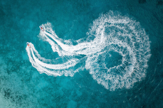 Aerial Top Down View Of People On Jet Skis Racing Around In Circle Formations Across The Blue Ocean Waves In Male, Maldives.
