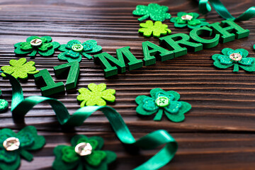 Handmade felt Shamrock leaves and letters 17 march on dark wooden background