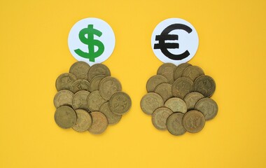 Diversification of currencies: dollar, euro. Saving money from inflation risks. Coins on yellow background. Investment planning and control concept. 