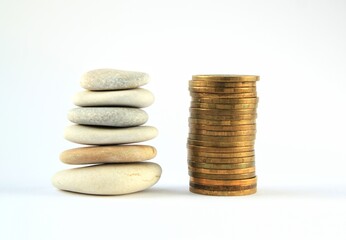 Fototapeta na wymiar Tower pyramids from coins and pebbles on grey background. Stability, growth, wealth, financial balance, saving money, business concept. Stack of zen stones and money. Flatlay, lay out. 