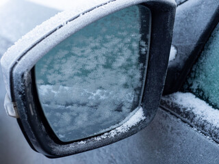 Snowflakes, snow crystals on the car mirror. Freeze, frost, macro
