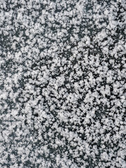 Snowflakes, snow crystals on the car roof. Freeze, frost, macro