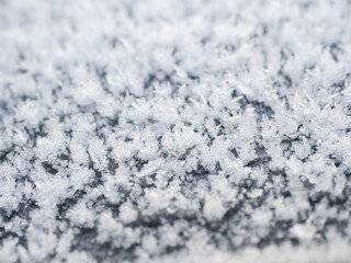Snowflakes, snow crystals on the car roof. Freeze, frost, macro