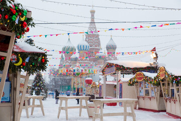 Moscow, Russia, February 7, 2022, fair on Red Square in the morning, winter, it is snowing. St. Basil's Cathedral through the snowfall. A white light image of Russian winter. 