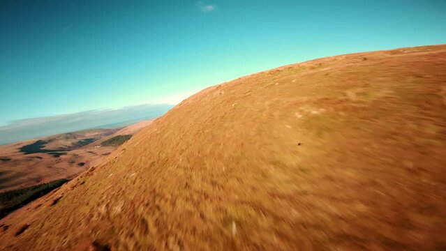 Aerial drone shot of Brecon Beacons with reservoir at the botom next to pen y fan peak. Drone video of fast flowing fpv view wales uk