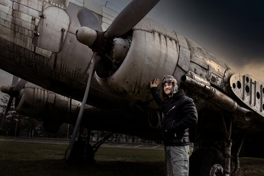 Portrait of young man airplane pilot. Airplane on the background.