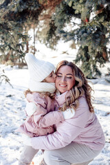 Obraz premium A little daughter and mother gently hug, kiss, showing love and expressing affection.Happy family, the pleasure of being a mom, congratulations on Mother's Day, the concept of a sweet moment together 