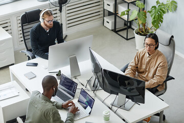 Group of young intercultural diversity programmers developing new programs in contemporary...