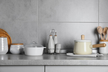 Fototapeta na wymiar Set of different cooking utensils on grey countertop in kitchen