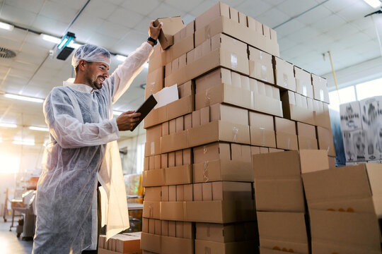 Inspector in a food factory using tablet and checking on products.
