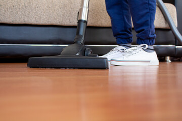 Fototapeta premium Woman using vacuum cleaner to cleaning parquet floor.