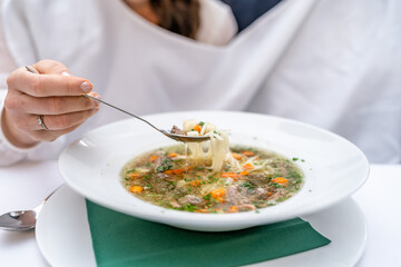 Wedding soup with perforated spoon, bib on newlyweds, festive traditions