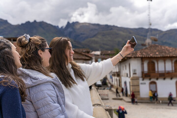 Fototapeta na wymiar Three friends taking a selfie standing in a traditional andean town