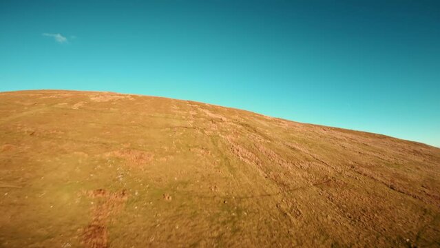 Aerial drone shot of Brecon Beacons with reservoir at the botom next to pen y fan peak. Drone video of fast flowing fpv view wales uk