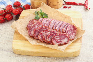 Sliced salami sausages over board