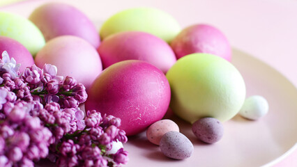 Fototapeta na wymiar Close-up of beautiful lilac Easter eggs with blooming lilac branches. Easter decor. Selective focus.