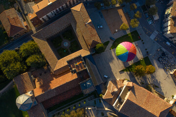 Aerial view of a hot ai balloon in Monestir square near Santa Maria de Ripoll monastery in Girona, Spain.