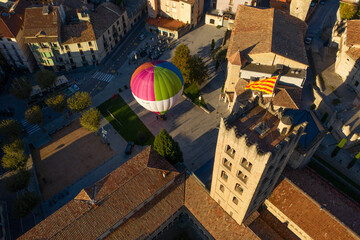 Aerial view of a hot ai balloon in Monestir square near Santa Maria de Ripoll monastery in Girona, Spain.