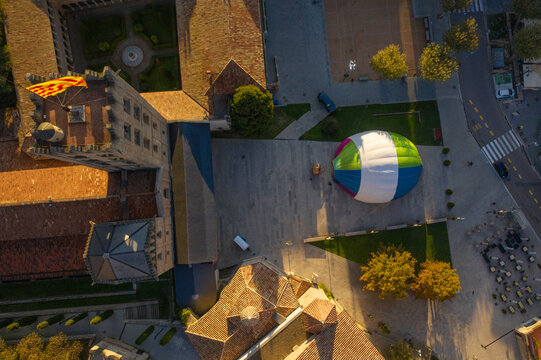 Aerial view of a hot ai balloon in Monestir square near Santa Maria de Ripoll monastery in Girona, Spain.