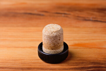 Bottle stopper made of natural cork material. On the background of a wooden texture