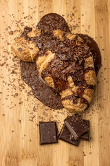 Croissant with chocolate on a wooden board