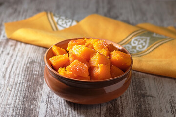 Baked pumpkin in a bowl on the table. Useful dessert.