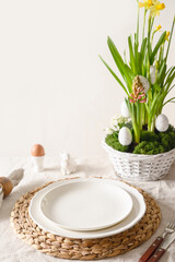 Happy Easter morning. Festive table setting with egg, bunny, fresh flowers in stylish flowerpot. Close up. Holiday spring traditional morning. Vertical format.