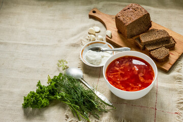 Borscht. Hearty lunch. Slices of bread, sour cream, greens.