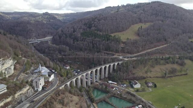 Beautiful landscape at medieval Village Saint-Ursanne, Canton Jura, with railway viaduct and river Doubs. Movie shot February 7th, 2022, Saint-Ursanne, Switzerland.