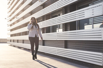 businesswoman talking on smartphone. African american woman in white plaid.