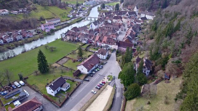 Medieval town Saint-Ursanne, Canton Jura, with beautiful facades of historic houses and river Doubs in the foreground. Movie shot February 7th, 2022, Saint-Ursanne, Switzerland.