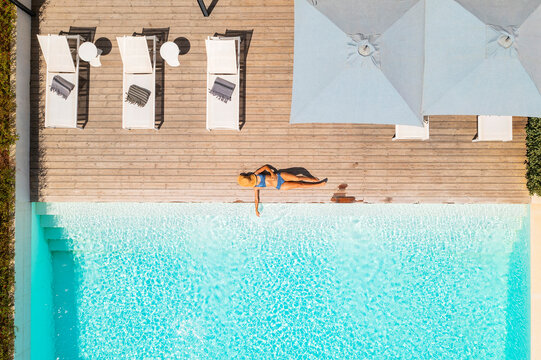 Aerial view of a blonde woman relaxing along the swimming pool of a luxury hotel, Beja, Portugal.