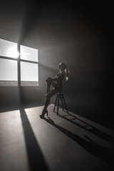 Sexy blonde in harness on a black cyclorama